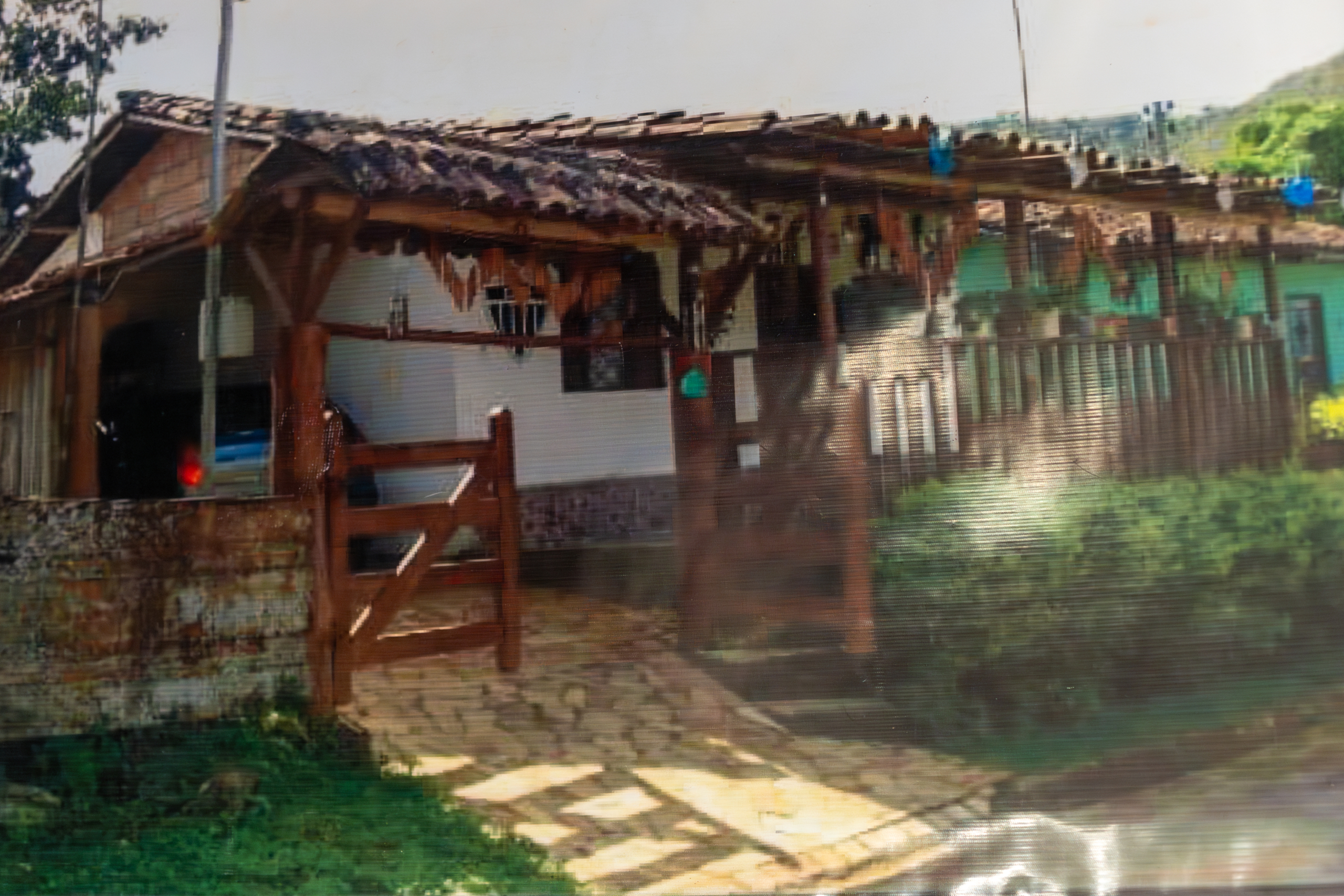 Casa da família Quintão em Bento Rodrigues de origem, antes do rompimento da barragem em 2015. Na imagem é possível ver o portão recuperado que hoje está na fachada da nova casa, no reassentamento.