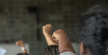 Punhos no ar em ato na Assembleia Legislativa de Belo Horizonte (foto de Fabiano Lana/Guaicuy).