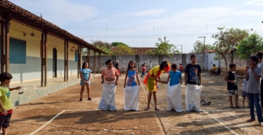 Crianças se preparam para corrida do saco em Festa Junina no Ribeirão do Bagre, Felixlândia