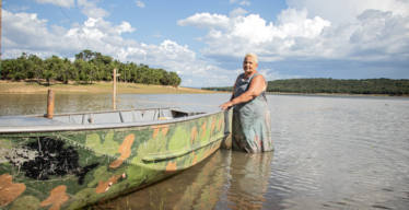 Mulher dentro de represa encostando em um barco