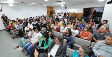 Auditório cheio com pessoas sentadas algumas em pé.
