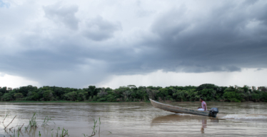 Pescador em seu barco navega o Rio São Francisco sob o céu nublado. Foto de Daniela Paoliello.
