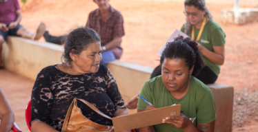 Trabalhadora do Guaicuy preenche formulário com pessoa atingida (foto: Gia Dias)