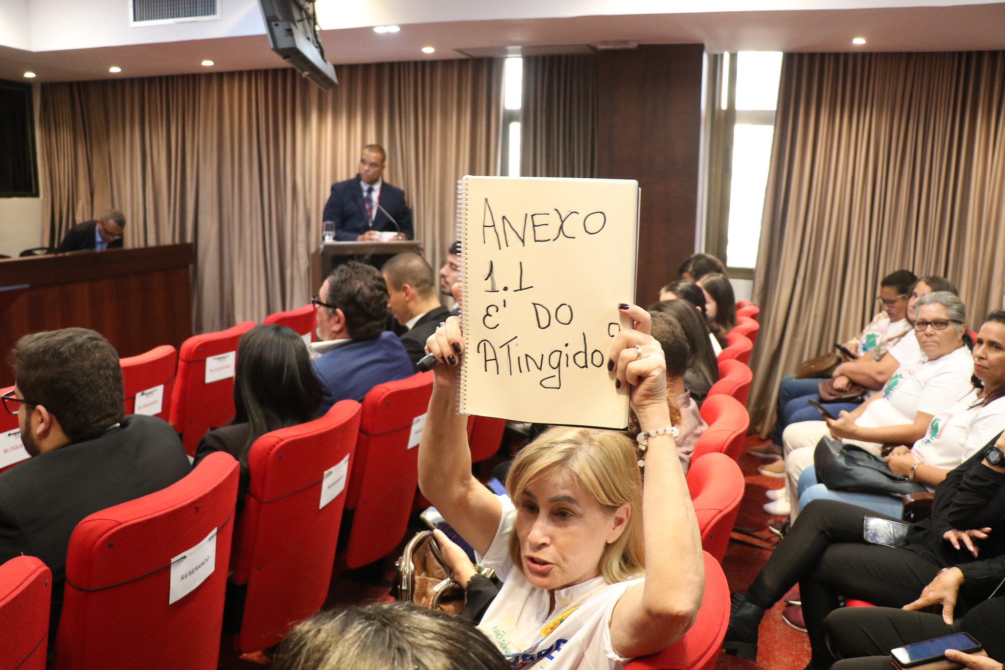 Mulher mostra cartaz escrito "Anexo 1.1 é do atingido" (foto: Paulo Marques).