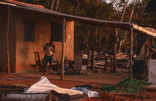 Homem carrega itens de imóvel ao lado de outras construções demolidas
