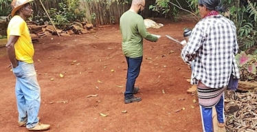 Dois homens e uma mulher de costas em espaço aberto rural