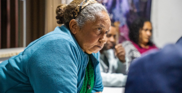 Reunião Ordinária da Comissão de Atingidos de Antônio Pereira. Imagem de mulher vestida com blusa azul e expressão séria.